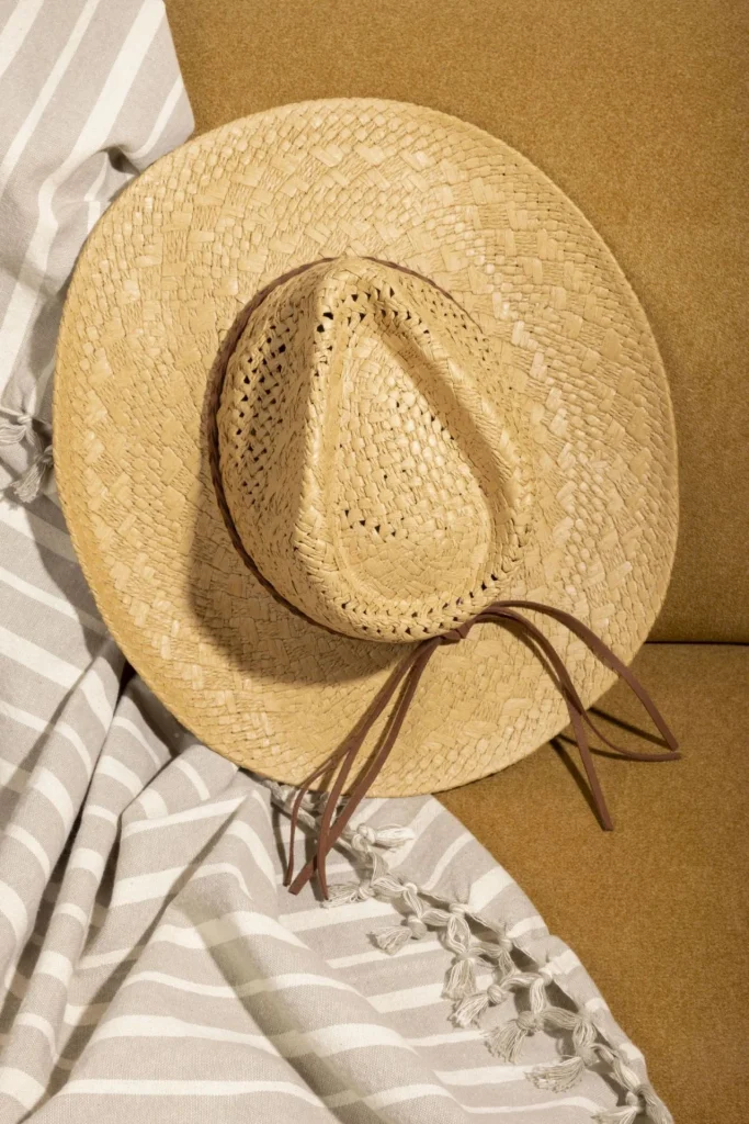 Sombrero de vaquero de paja sobre una manta de rayas