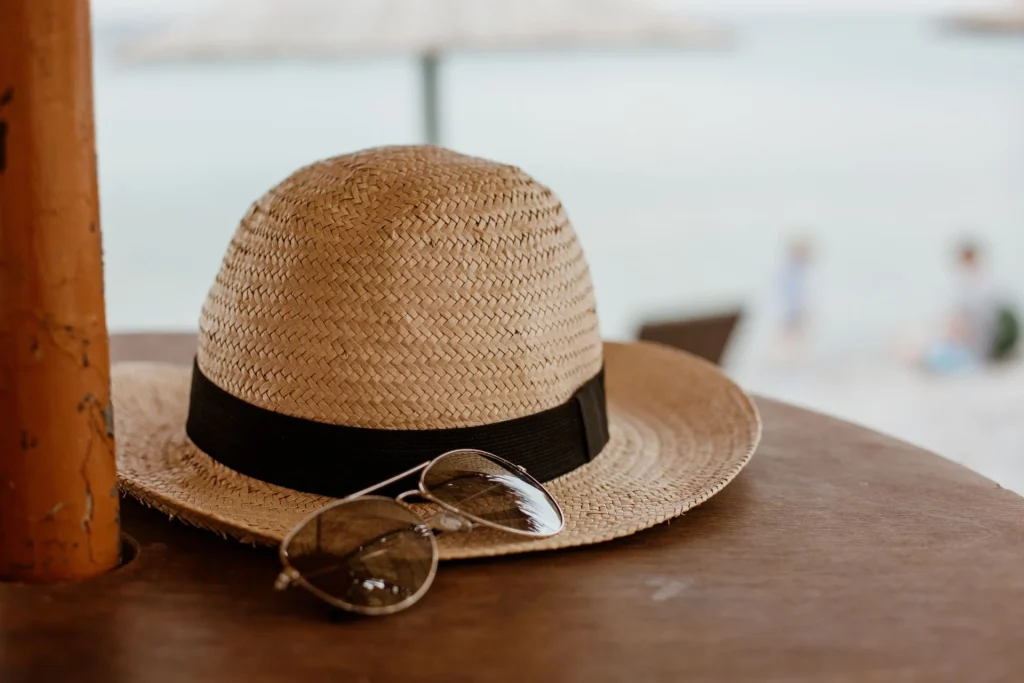 Straw hat and sunglasses on a table Straw hat and sunglasses on a table