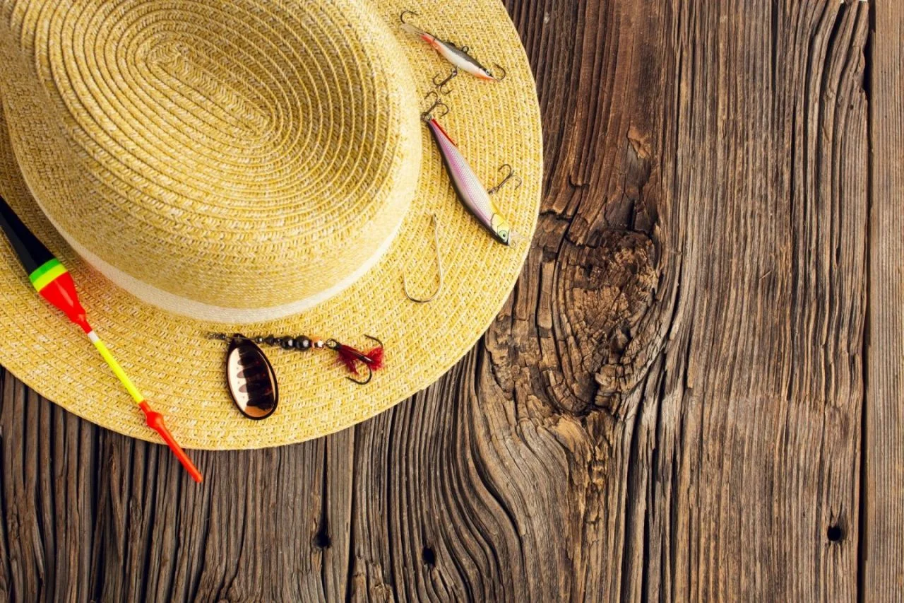 Straw hat with fishing lures on wood Straw hat with fishing lures on wood