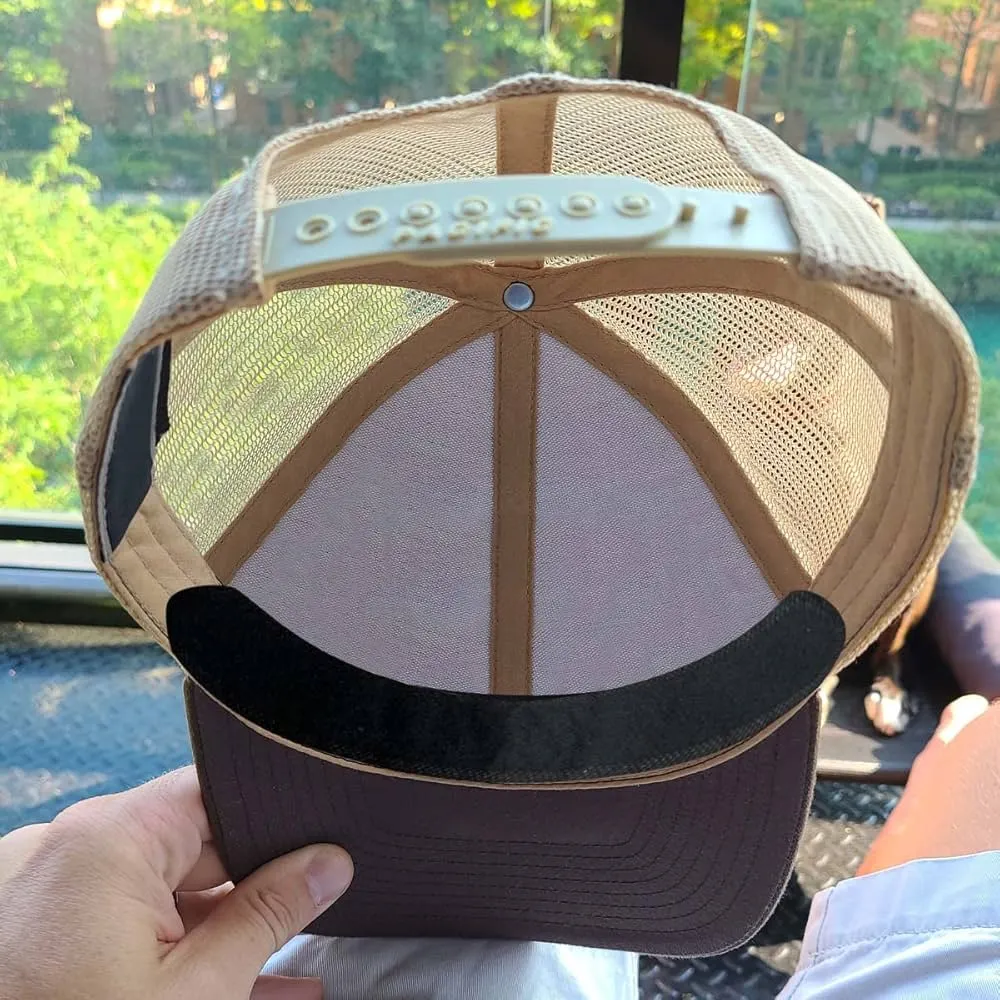 A person is holding a hat featuring a distinctive black and white logo