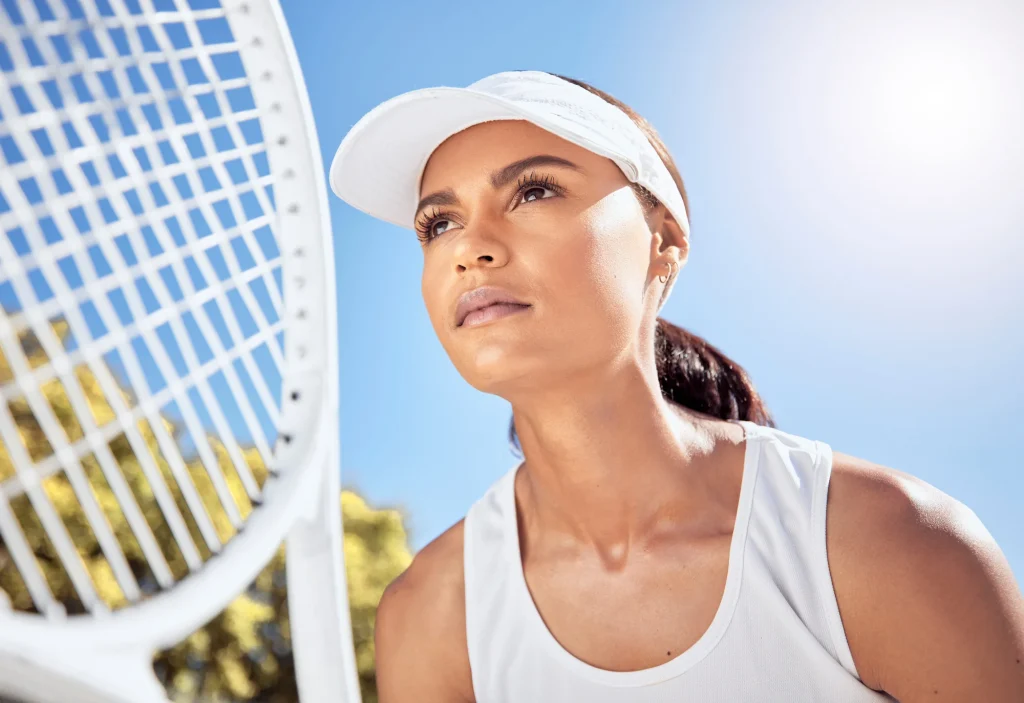 Focused woman in white visor under clear blue sky