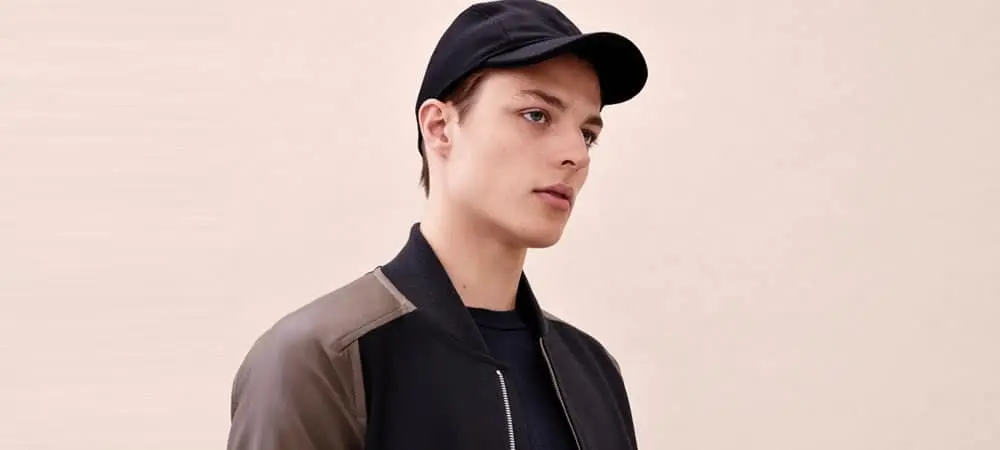 Man wearing a black baseball cap and bomber jacket Man wearing a black baseball cap and bomber jacket