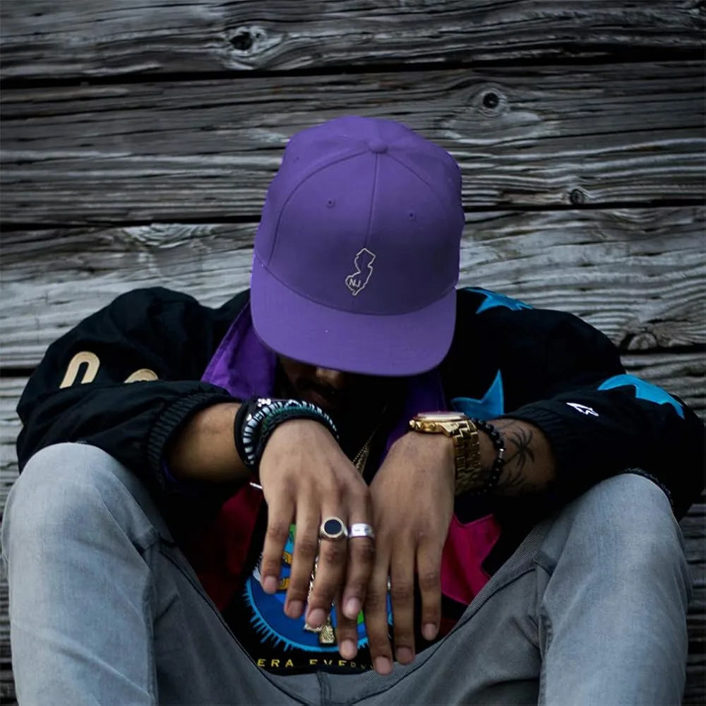 Mann trägt lila Kappe mit dem New Jersey-Umriss-Logo mit gesenktem Kopf – Entdecken Sie die neuesten Erkenntnisse im Bereich Kopfbedeckungen – JoinTop | Hersteller von kundenspezifischen Hüten und Kappen | OEM- und ODM-Fabrik für Kopfbedeckungen – JoinTop | Hersteller von kundenspezifischen Hüten und Kappen | OEM- und ODM-Fabrik für Kopfbedeckungen Mann trägt lila Kappe mit New Jersey-Umriss-Logo, Kopf nach unten