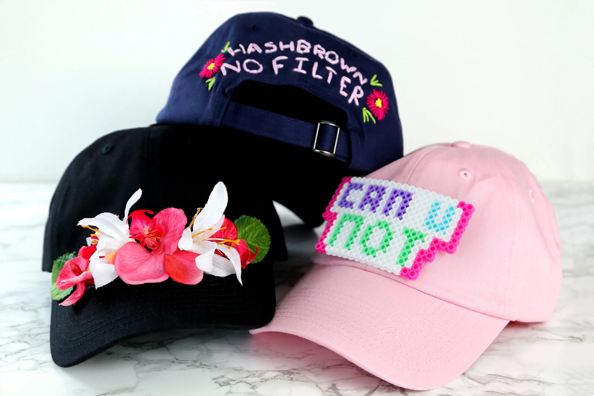 Three hats featuring embroidered flowers Three hats featuring embroidered flowers