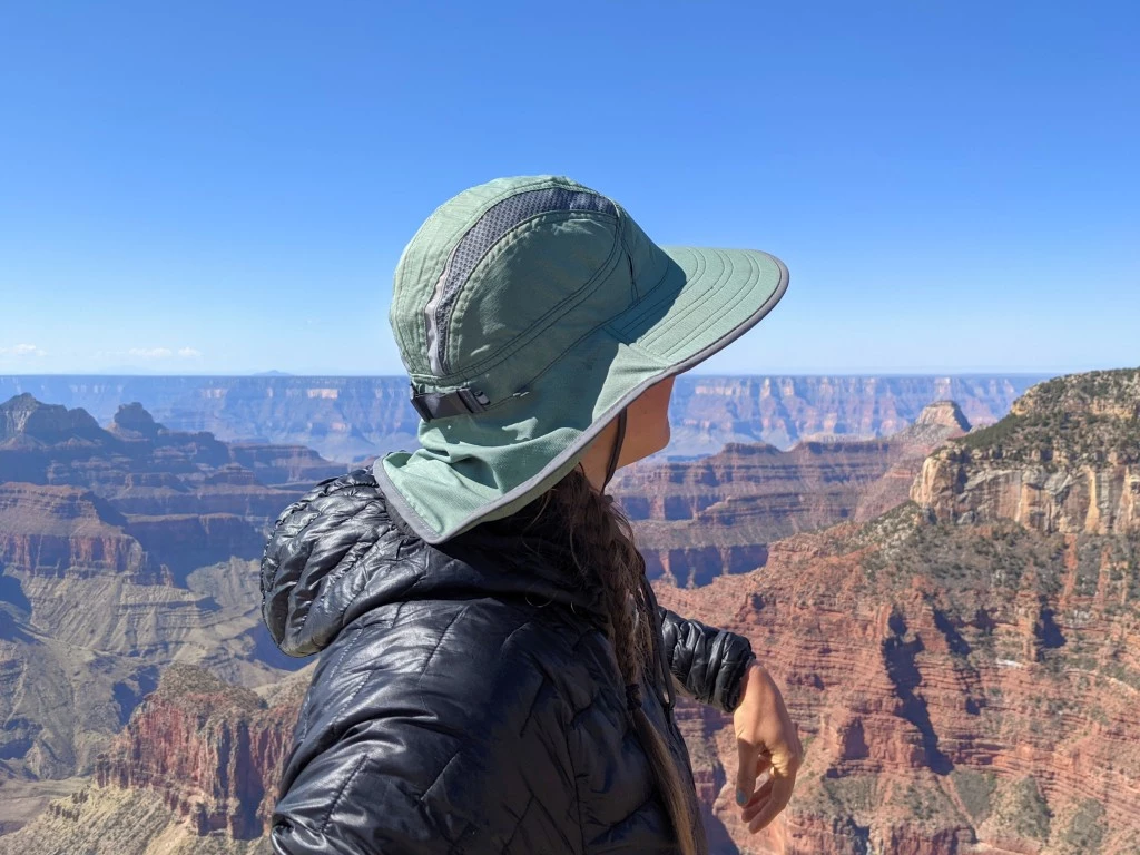 Woman in green hat overlooks the Grand Canyon