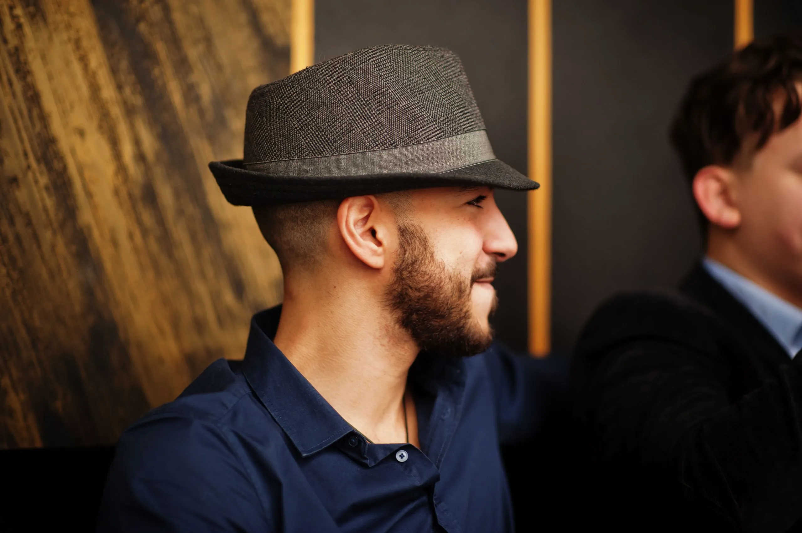Mann mit dunklem Fedora und blauem Hemd