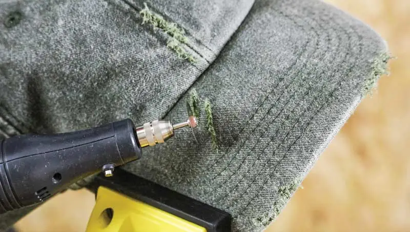 Dremel on Cap Tool distressing a green caps fabric