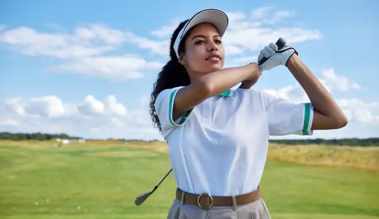 woman playing golf wearing a golf hat