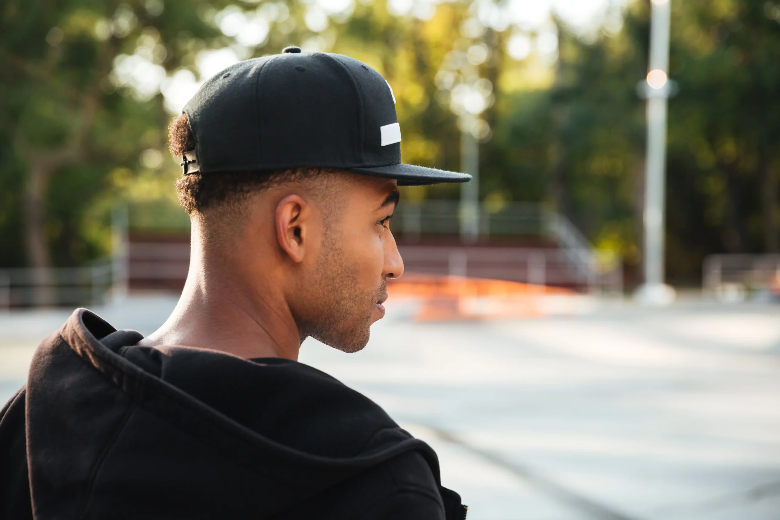 medium shot smiley man wearing trucker hat close up young african man cap looking away