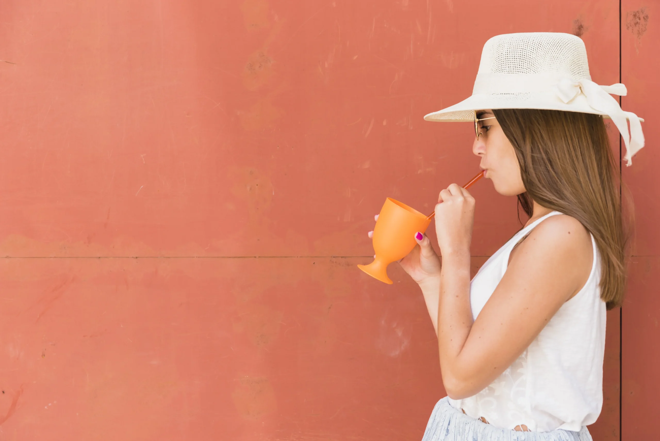 young woman hat holding cup drinking through straw compressed young woman hat holding cup drinking through straw compressed