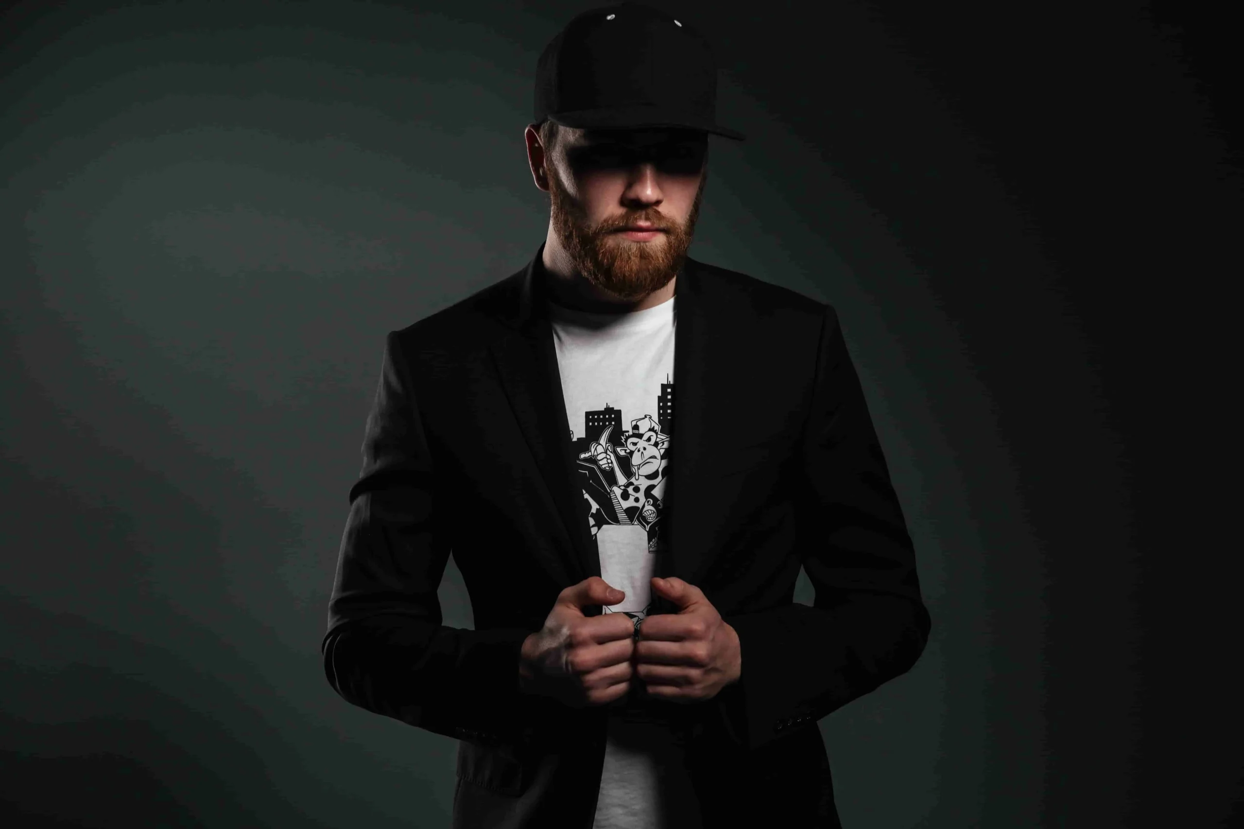 Hombre con traje negro, camiseta blanca y gorra de béisbol negra