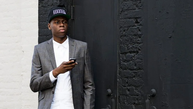 Man in gray suit with black baseball cap