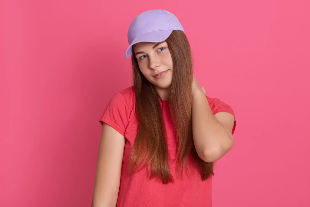 portrait woman holding her neck discomfort against pink background female with neck pain