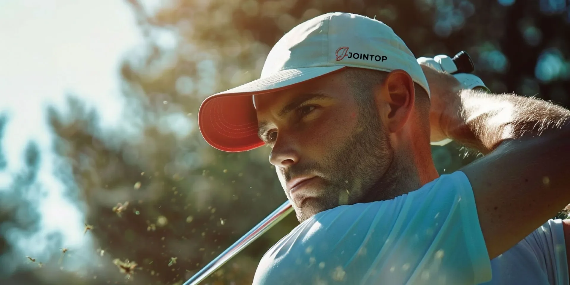 A golfer with a white cap swings against the sun A golfer with a white cap swings against the sun