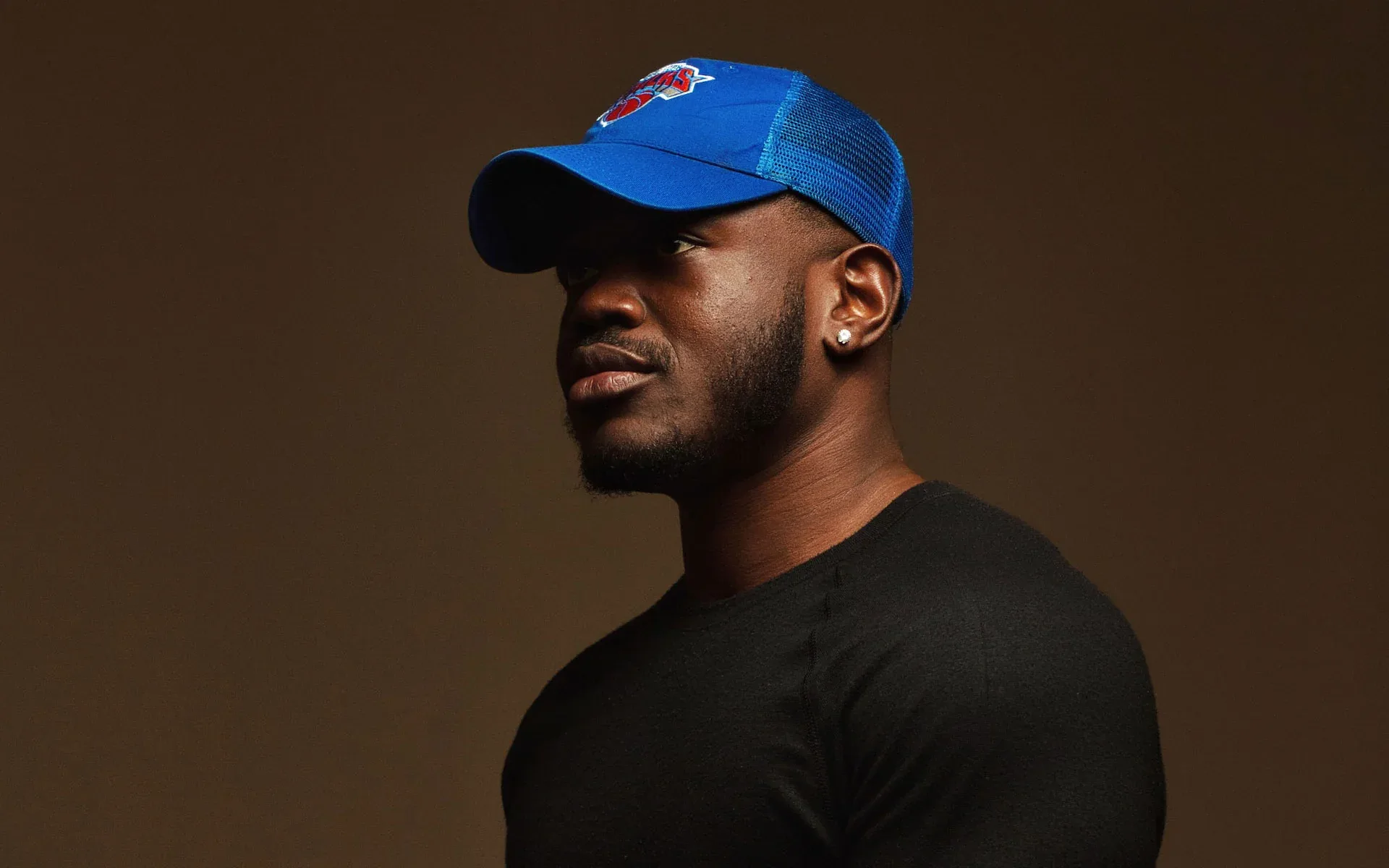 A man is wearing a stylish black trucker cap A man is wearing a stylish black trucker cap