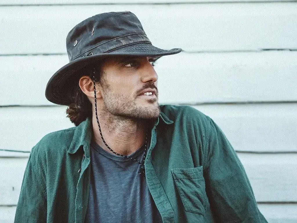 Man wearing black waterproof outdoor hat Man wearing black waterproof outdoor hat