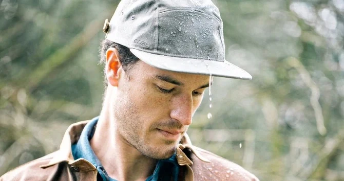 Man wearing gray waterproof cap in rain Man wearing gray waterproof cap in rain