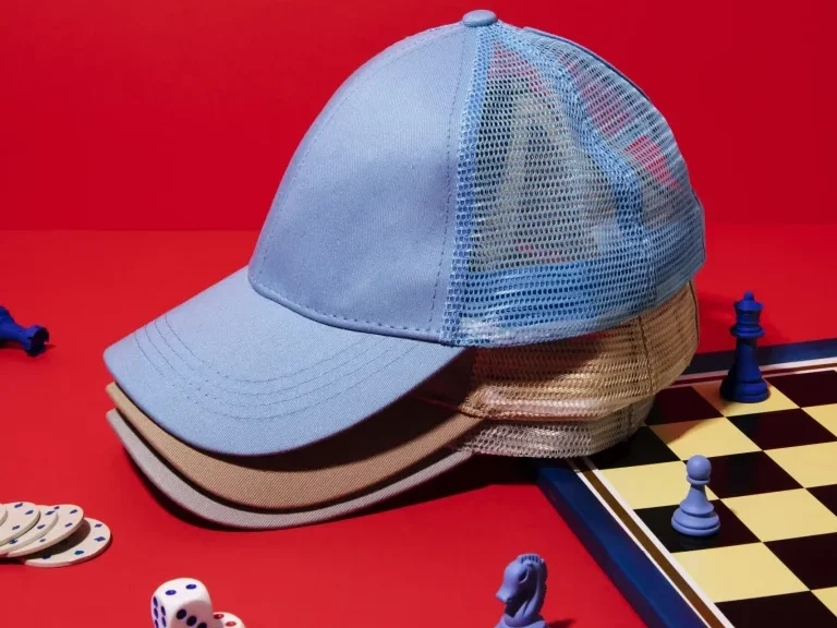 Pila de gorras sostenibles estilo camionero cerca de un tablero de ajedrez Pila de gorras sostenibles estilo camionero cerca de un tablero de ajedrez