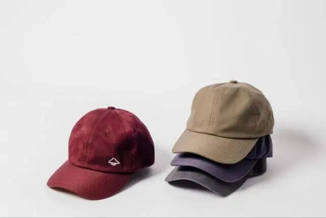 Stack of plain sustainable caps in multiple colors Stack of plain sustainable caps in multiple colors