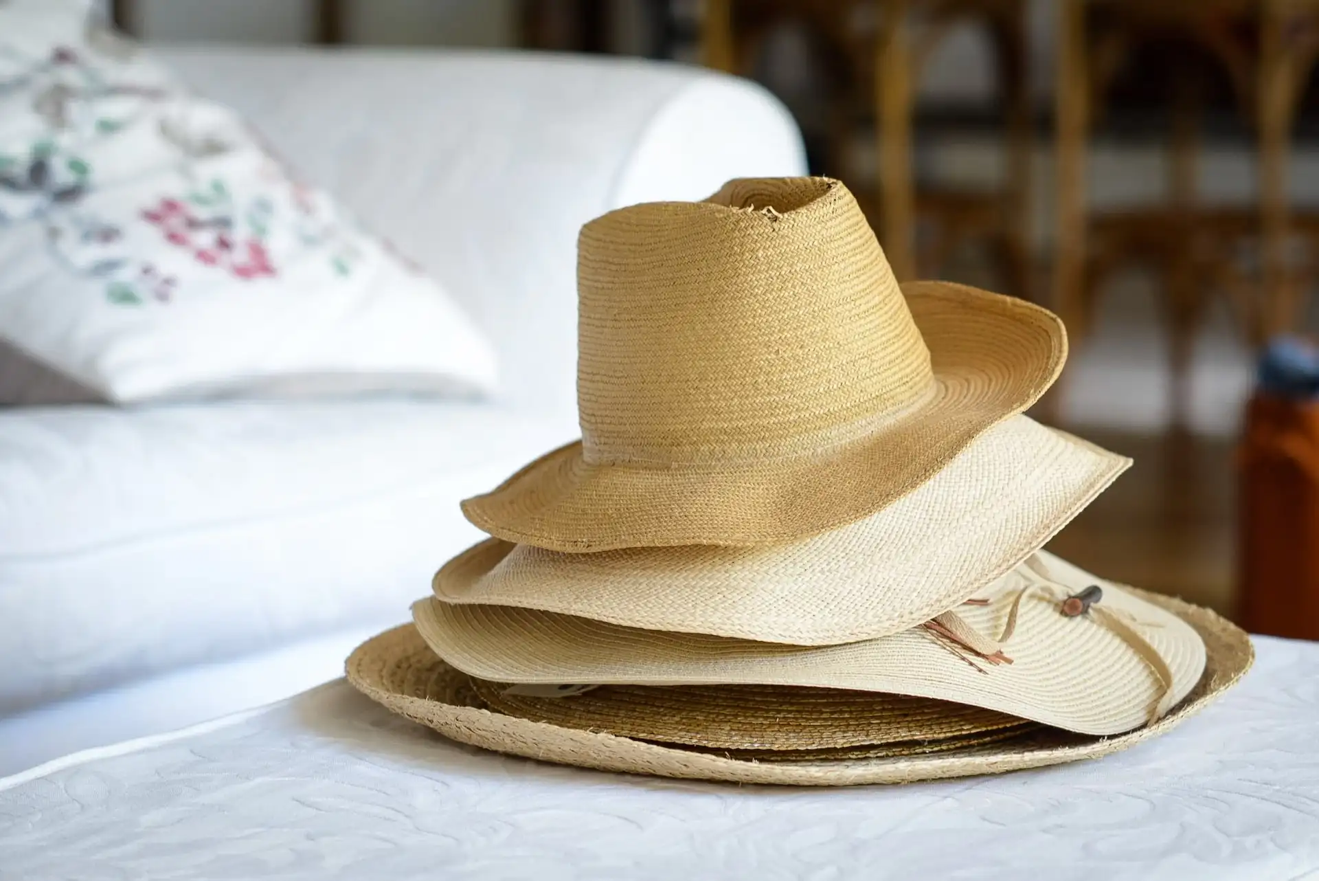 Stack of straw sustainable hats on white table Stack of straw sustainable hats on white table