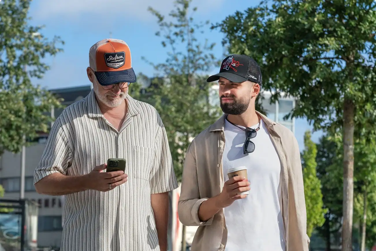 Two men wearing trucker caps outdoors Two men wearing trucker caps outdoors