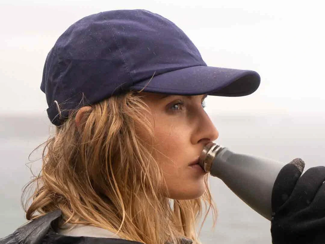 Woman wearing navy waterproof cap outdoors Woman wearing navy waterproof cap outdoors