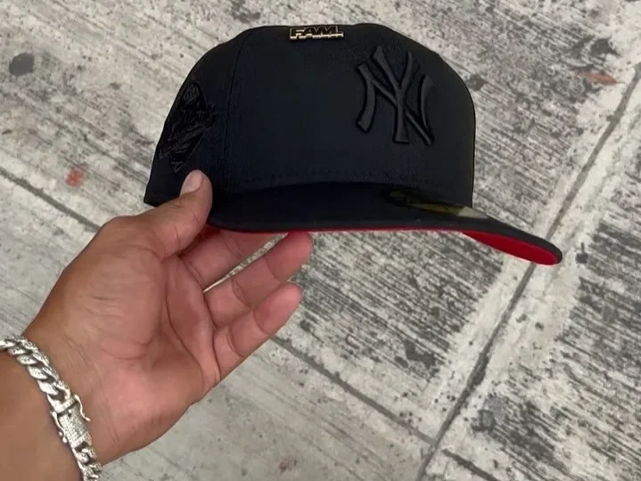 Mano sosteniendo una gorra negra de los Yankees de New Era Mano sosteniendo una gorra negra de los Yankees de New Era